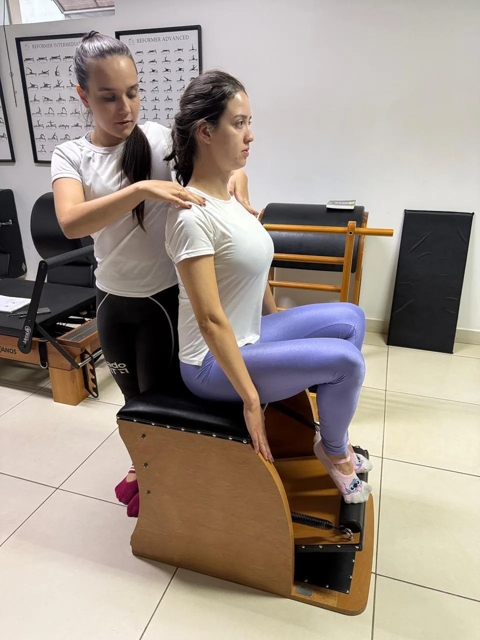 Instrutora orientando aluna durante exercício na Wunda Chair